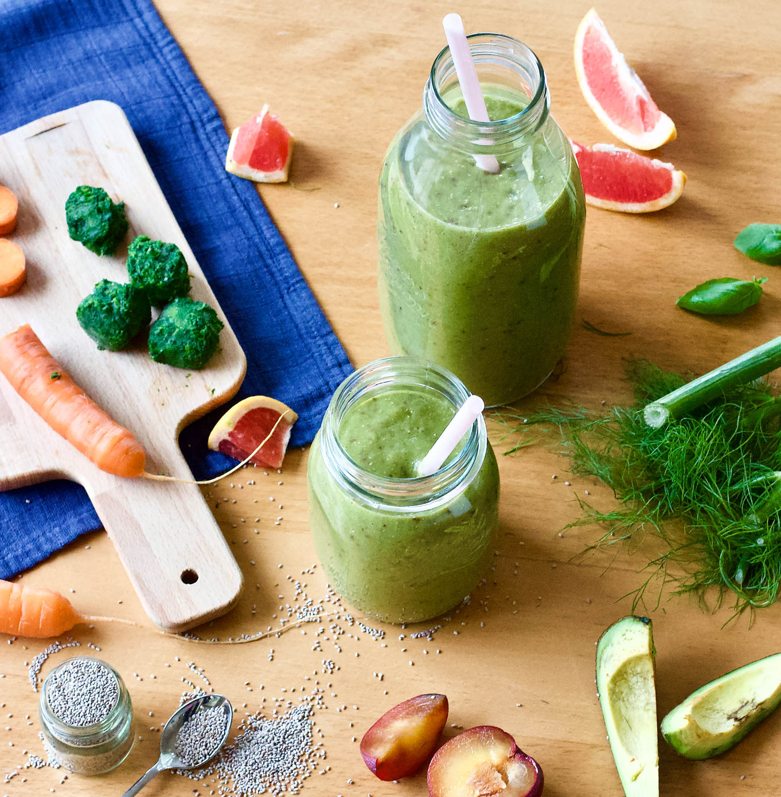 Two jars of freshly made Glowing Skin Green Smoothie and plants around on a table