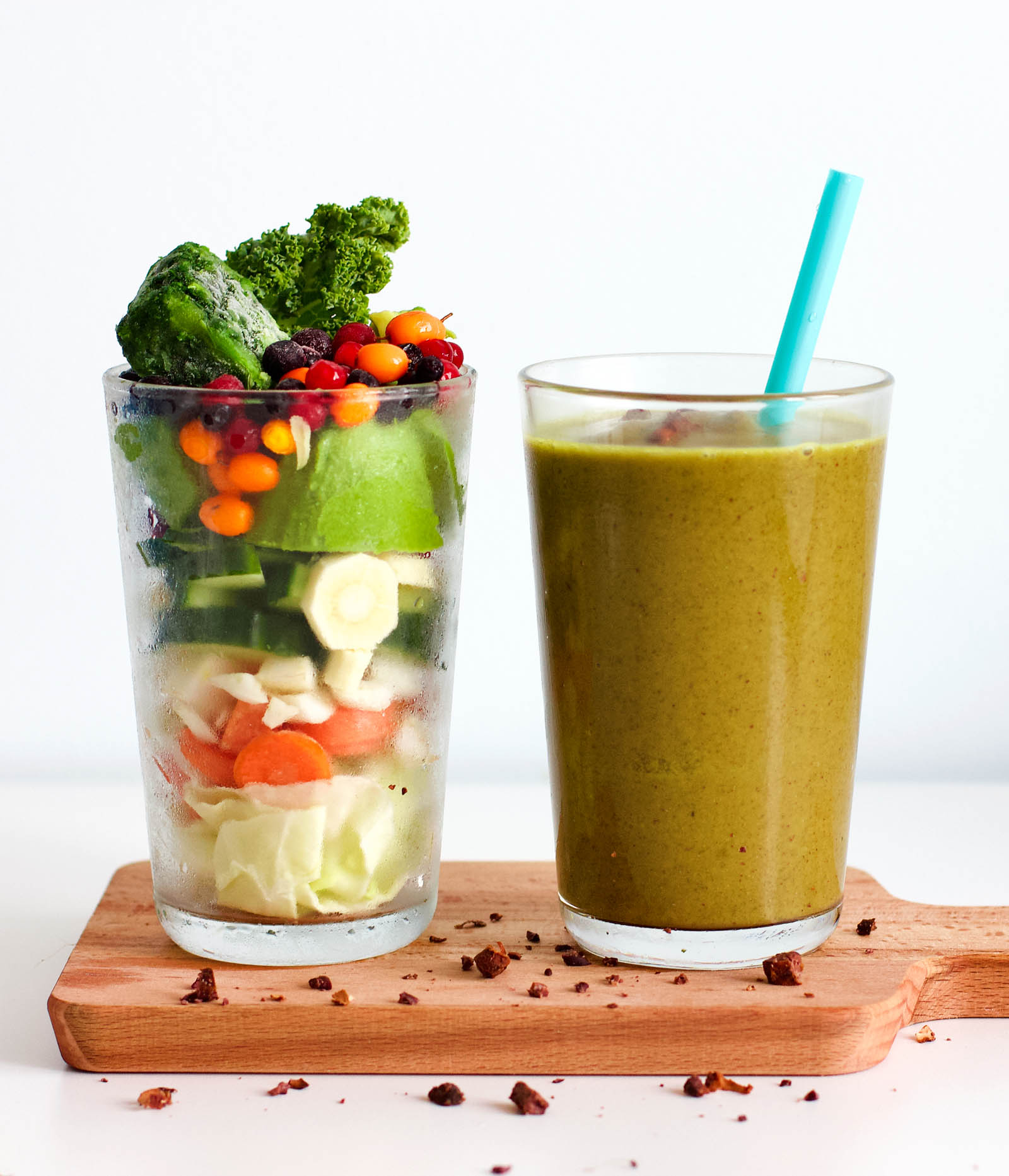 Glass with fresh plants near another glass with freshly made Super Green Shot Energy Smoothie