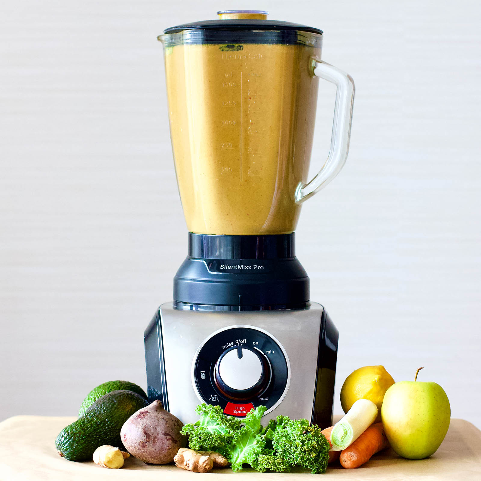 Blender with freshly made Double Veggie Surprise Smoothie and plants around it on a table
