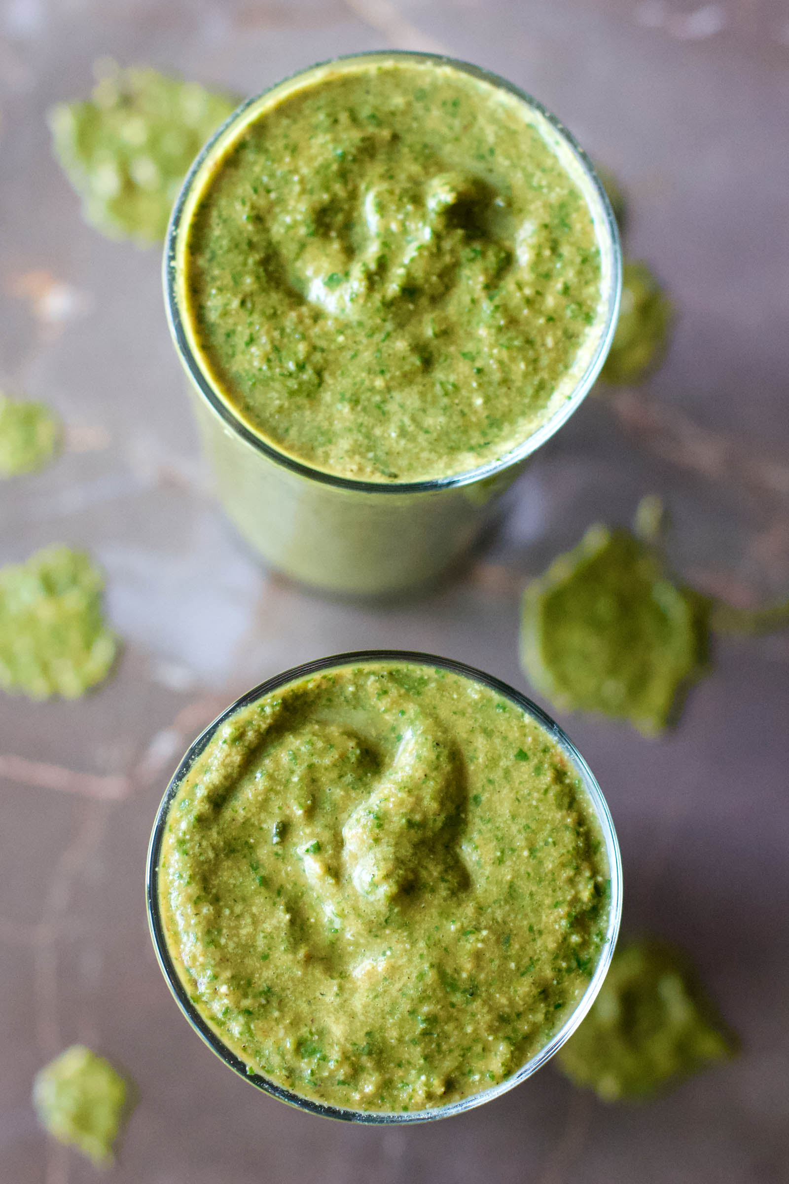 Two glasses of Healthy Greens Power-Up Smoothie on a table, top-down view