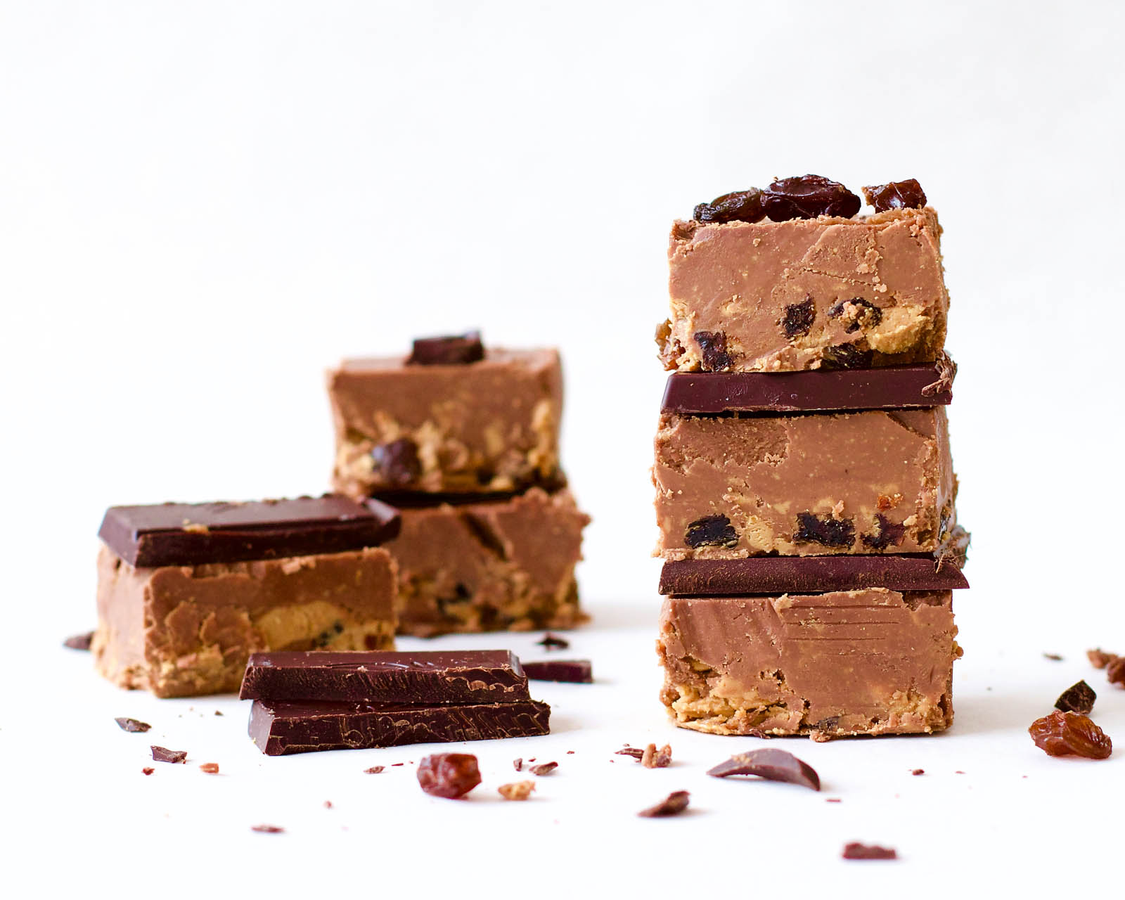 Stacked Delicious Cashew Butter Fudge raw cookies and a few on the side, on a white background
