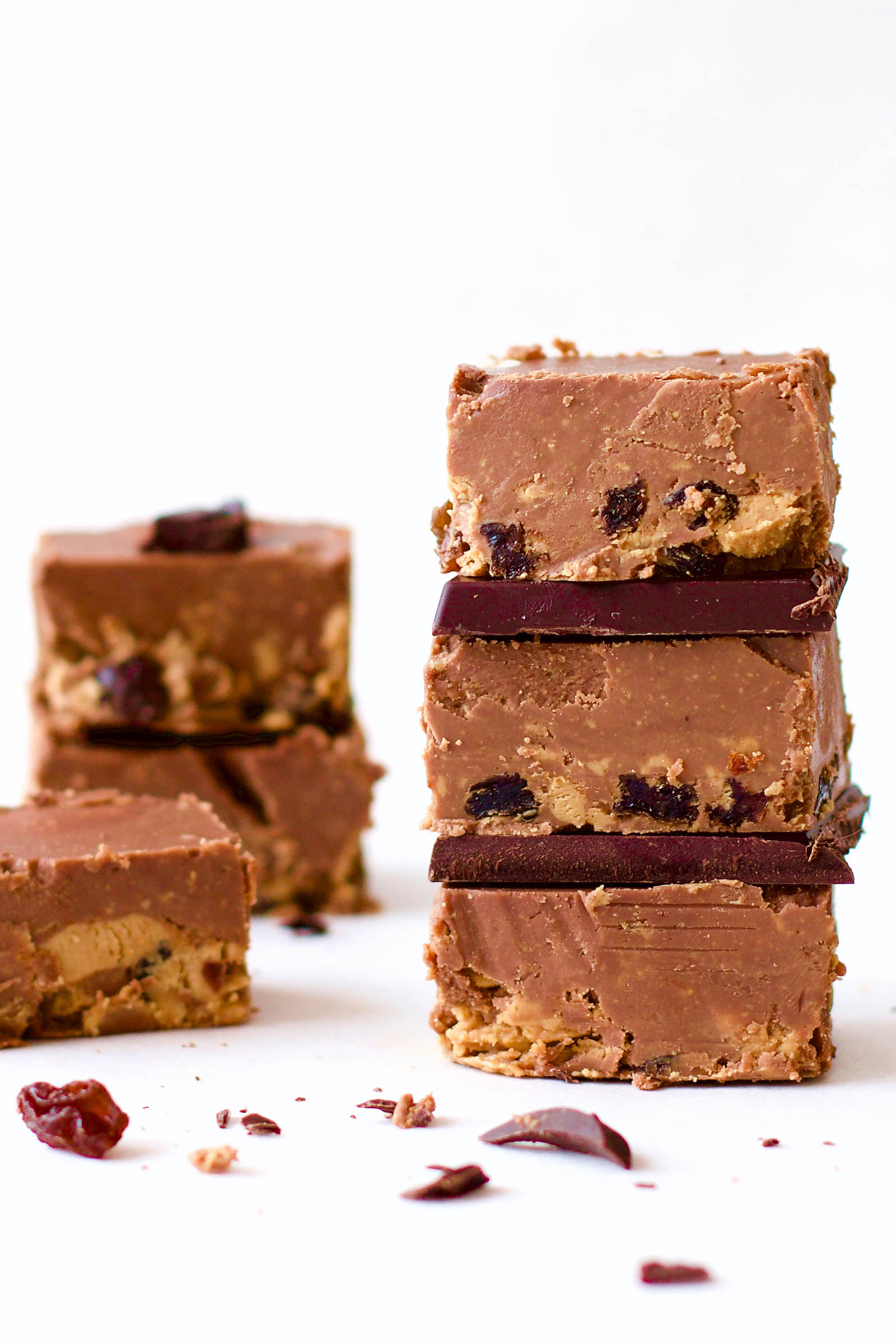 Stacked Delicious Cashew Butter Fudge raw cookies and a few on the side, on a white background
