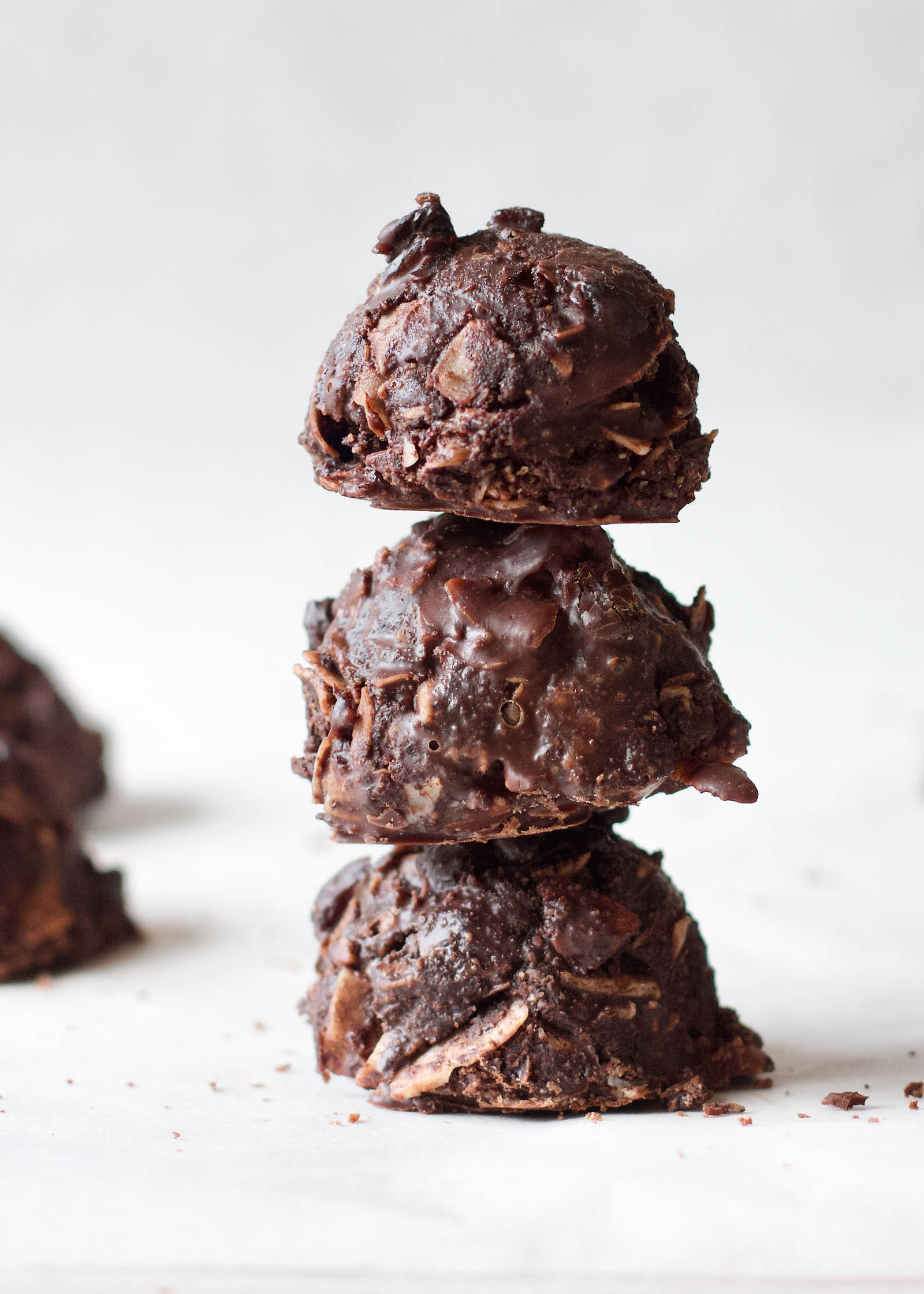 Stack of three Chocolate Coconut Macaroons on a white backdrop, close-up shot