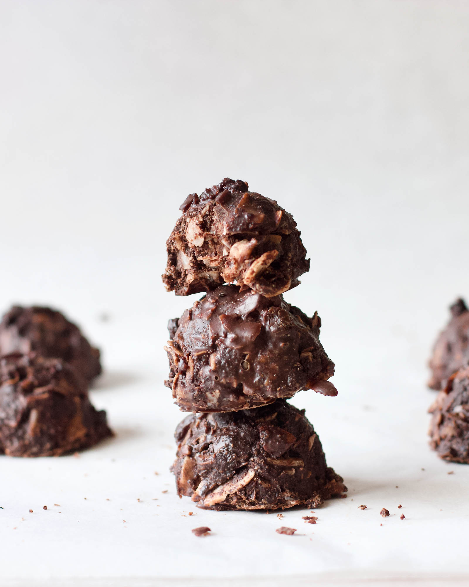 Stack of three Chocolate Coconut Macaroons on a white backdrop, close-up shot