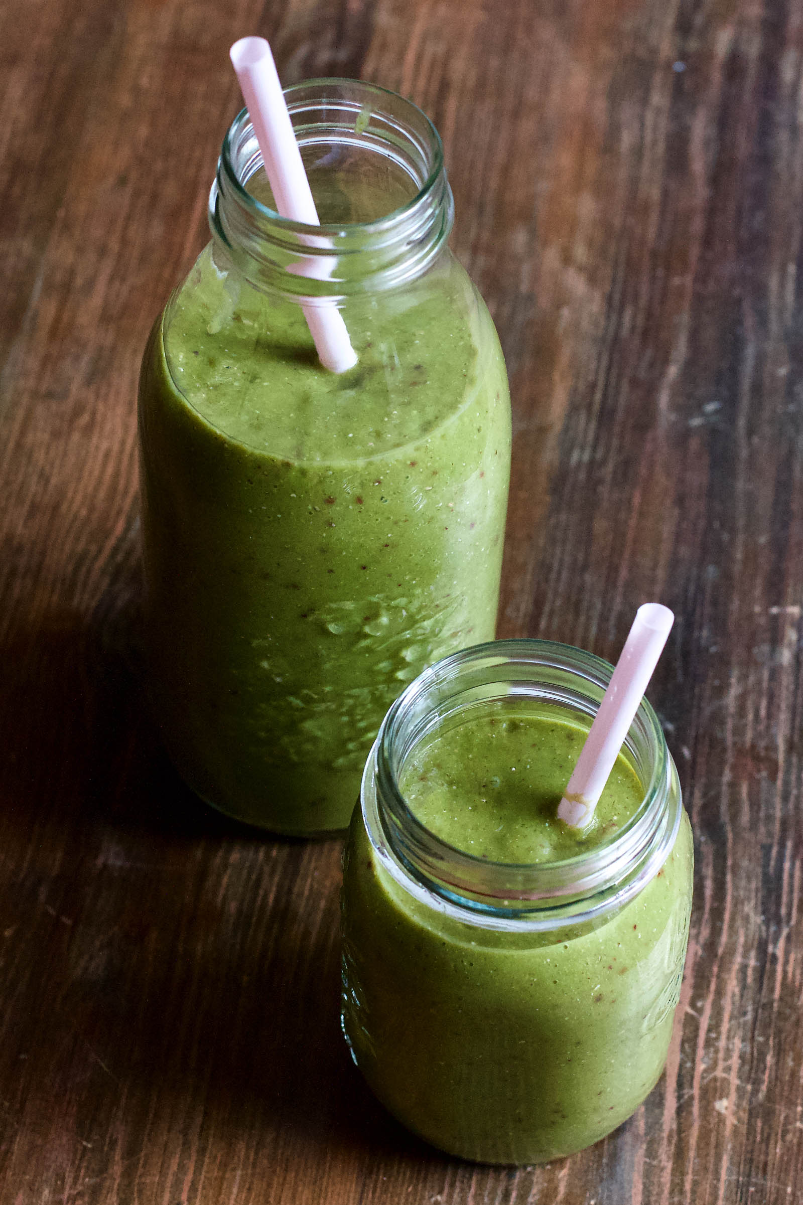 Glowing Skin Green Smoothie presentation in two jars on a wooden table