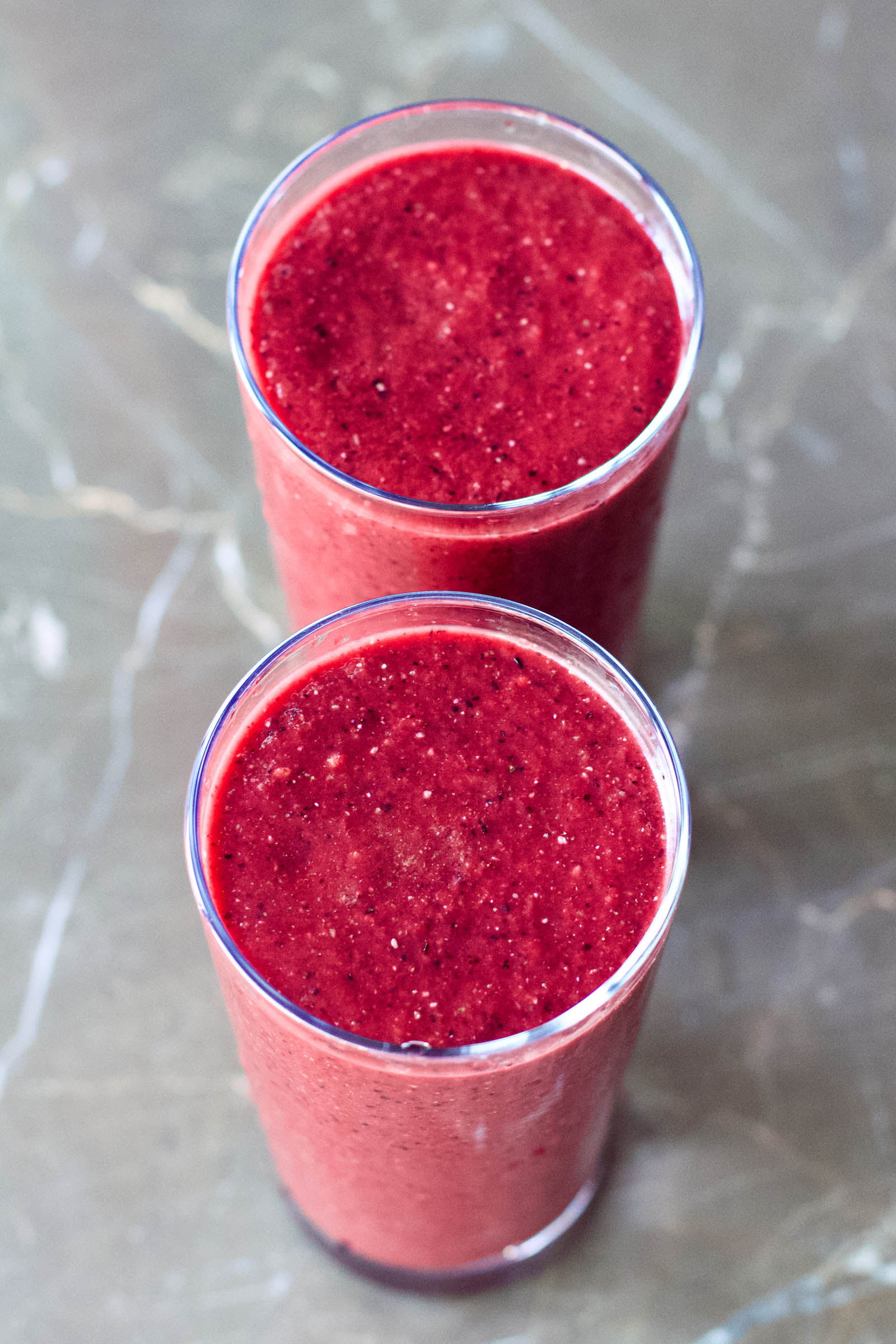 Two glasses with Refreshing Spicy and Sweet Red Smoothie on a table, top-down view