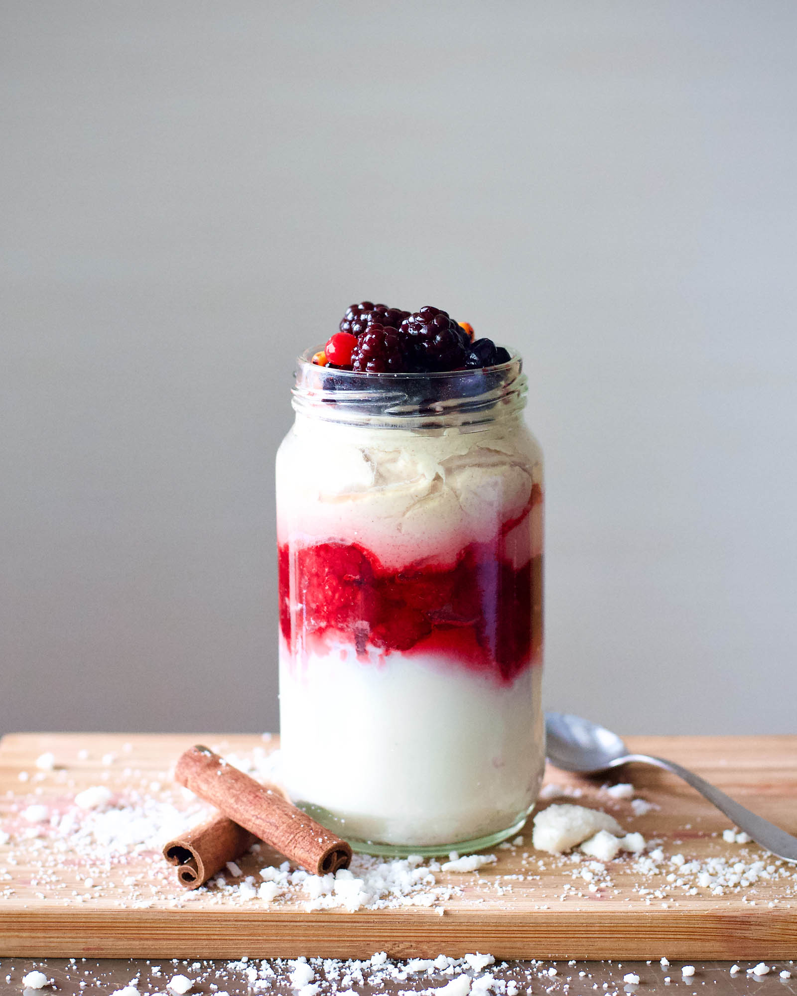 One serving of homemade Coconut, Berries and Whipped Cream Parfait placed on a wooden board, hero shot