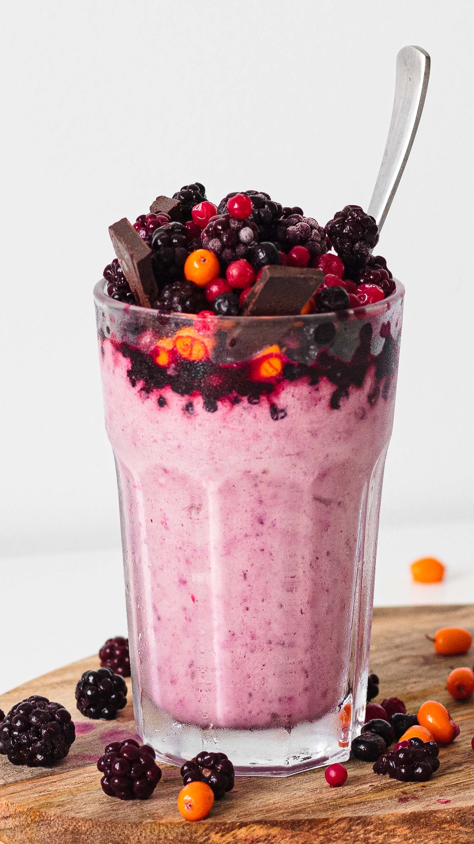 Glass with freshly made Keto Frozen Berry Milkshake on a white background, close-up