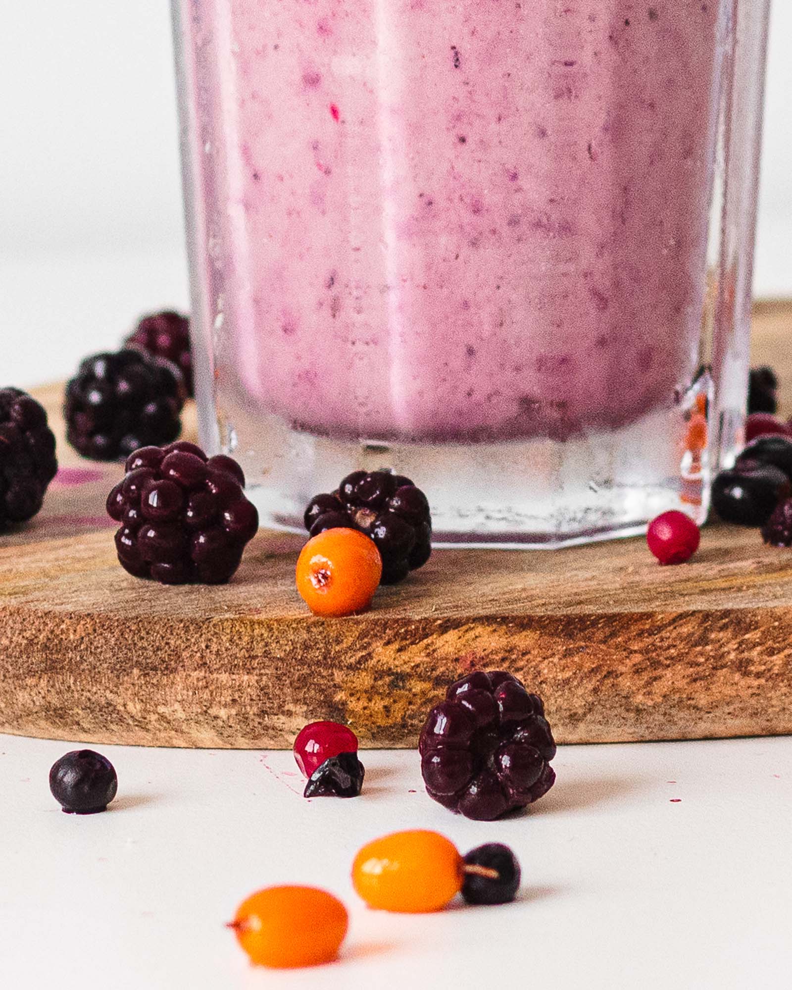 Bottom part of glass with freshly made Keto Frozen Berry Milkshake, close-up