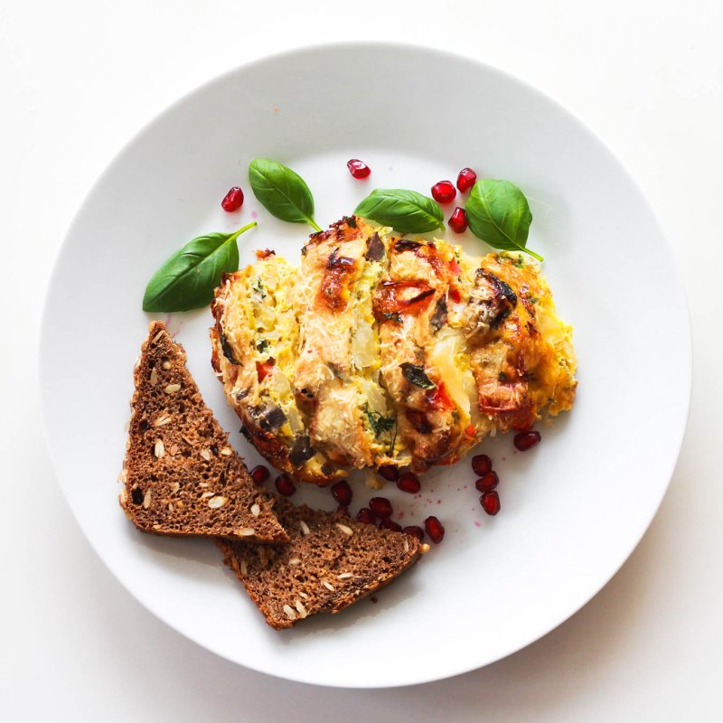 Super Easy Frittata Cavolo in white round plate, served with rye bread, top-down view