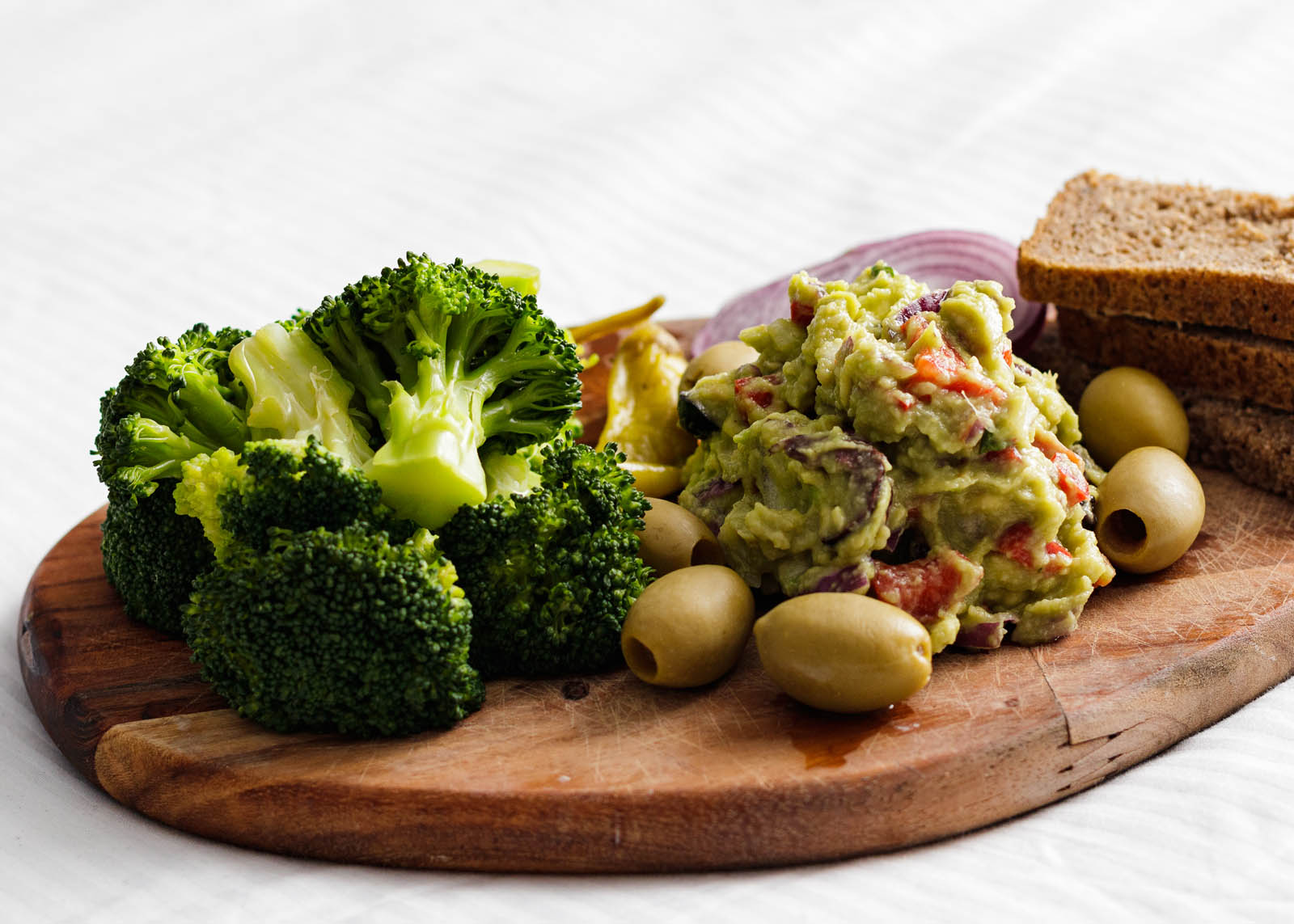 Broccoli and Guacamole Plateau on a white background, side view