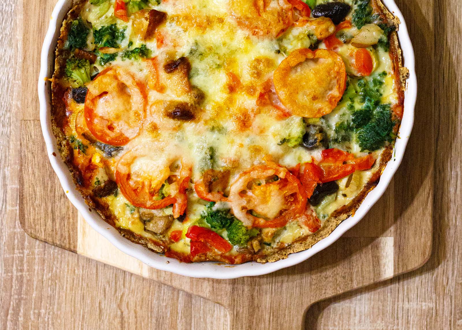 Close-up top-down view of homemade Keto Pizza on a wooden table