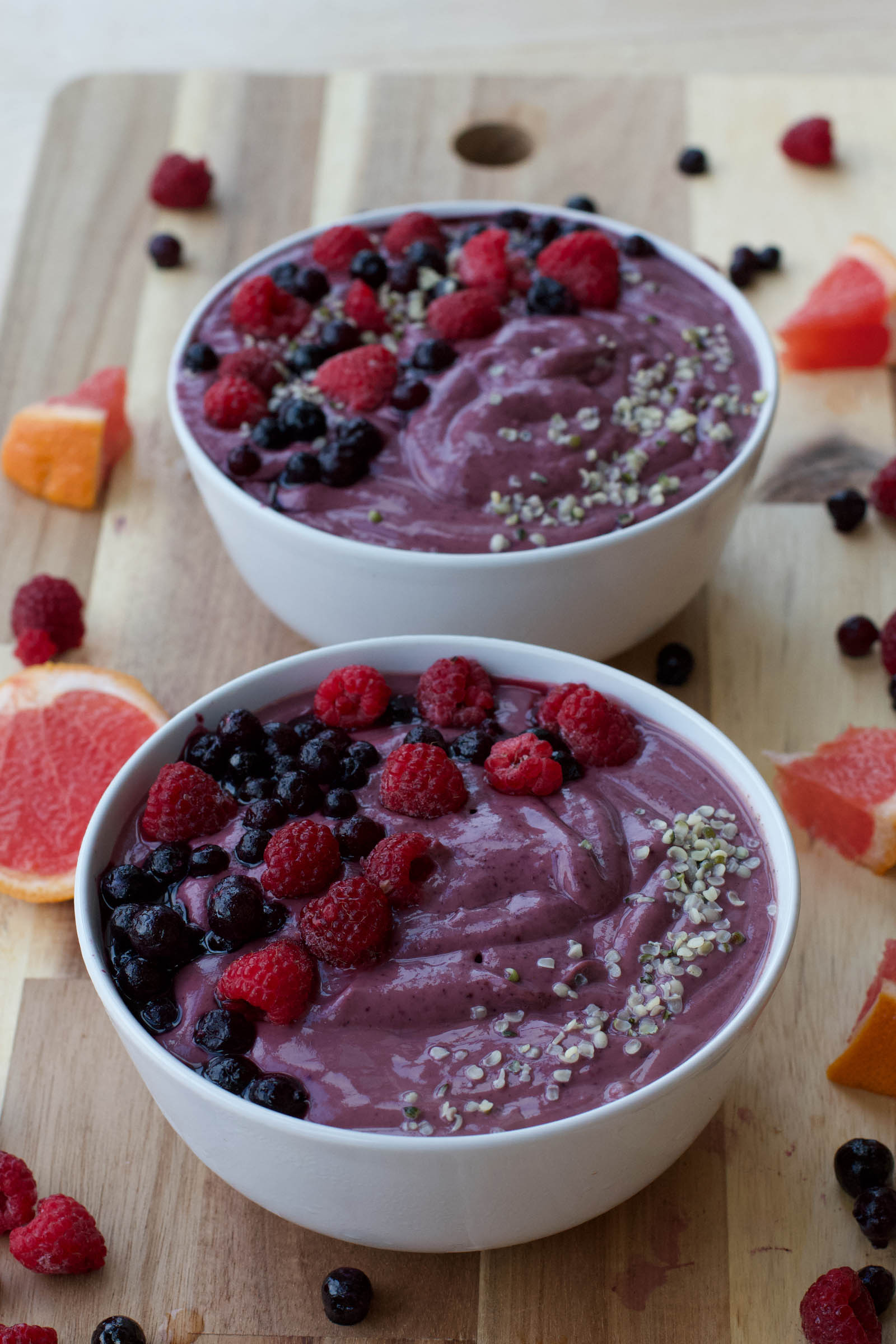 Two bowls of freshly made Purple Smoothie Bowl on a wooden table
