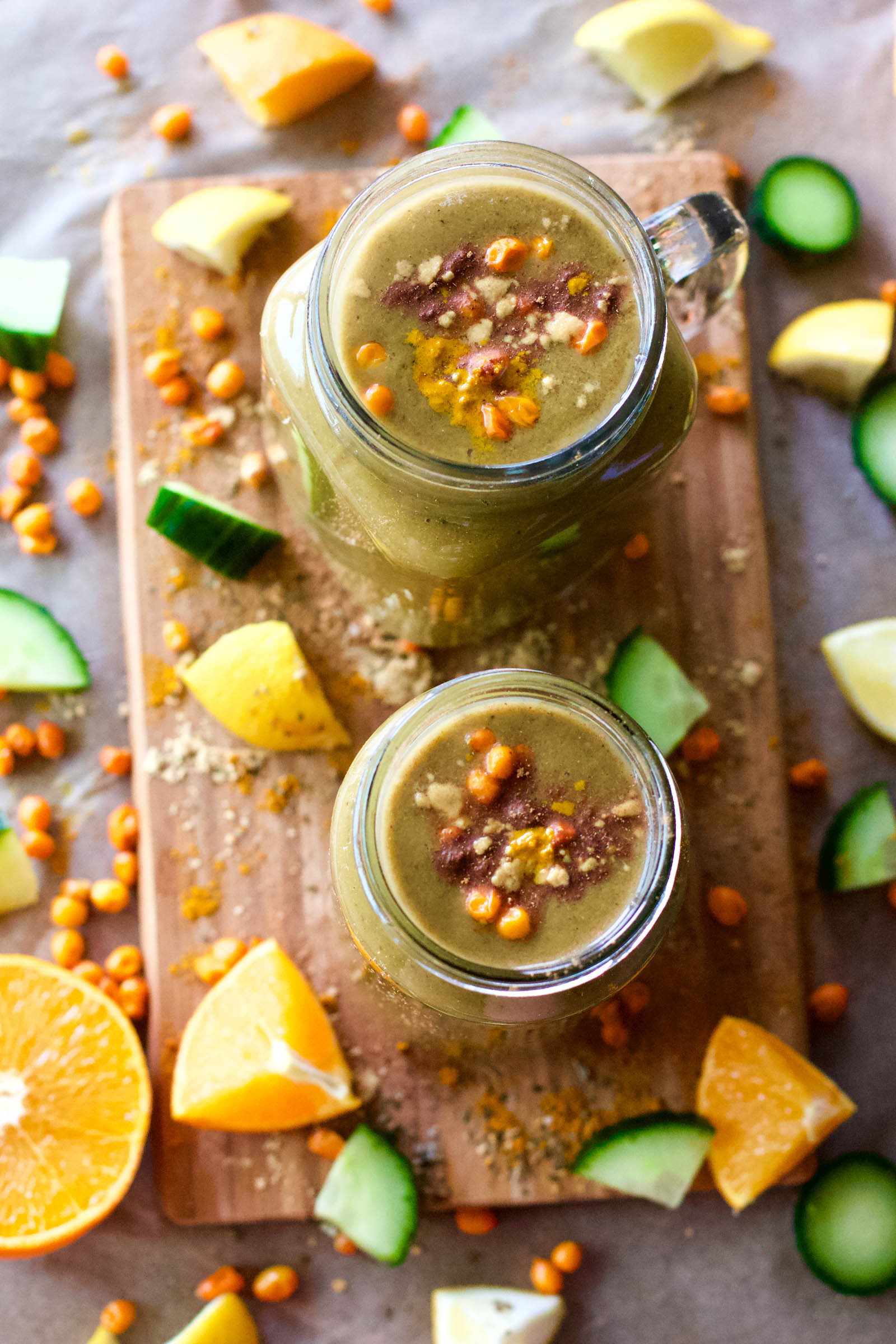 Top-down view of two jars with Spicy Creamy Green Springtime Smoothie on a wooden board