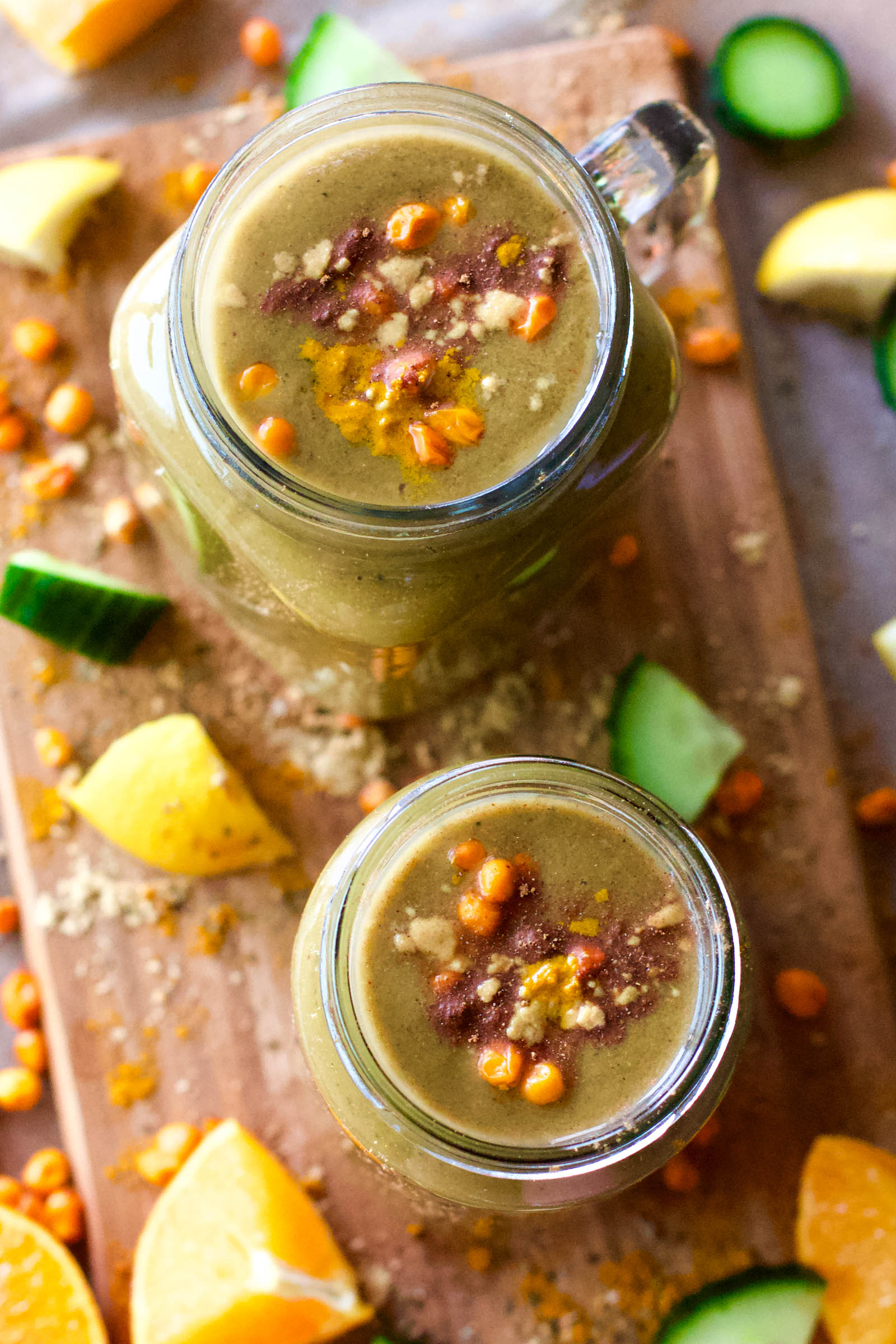 Top-down view of two jars with Spicy Creamy Green Springtime Smoothie on a wooden board