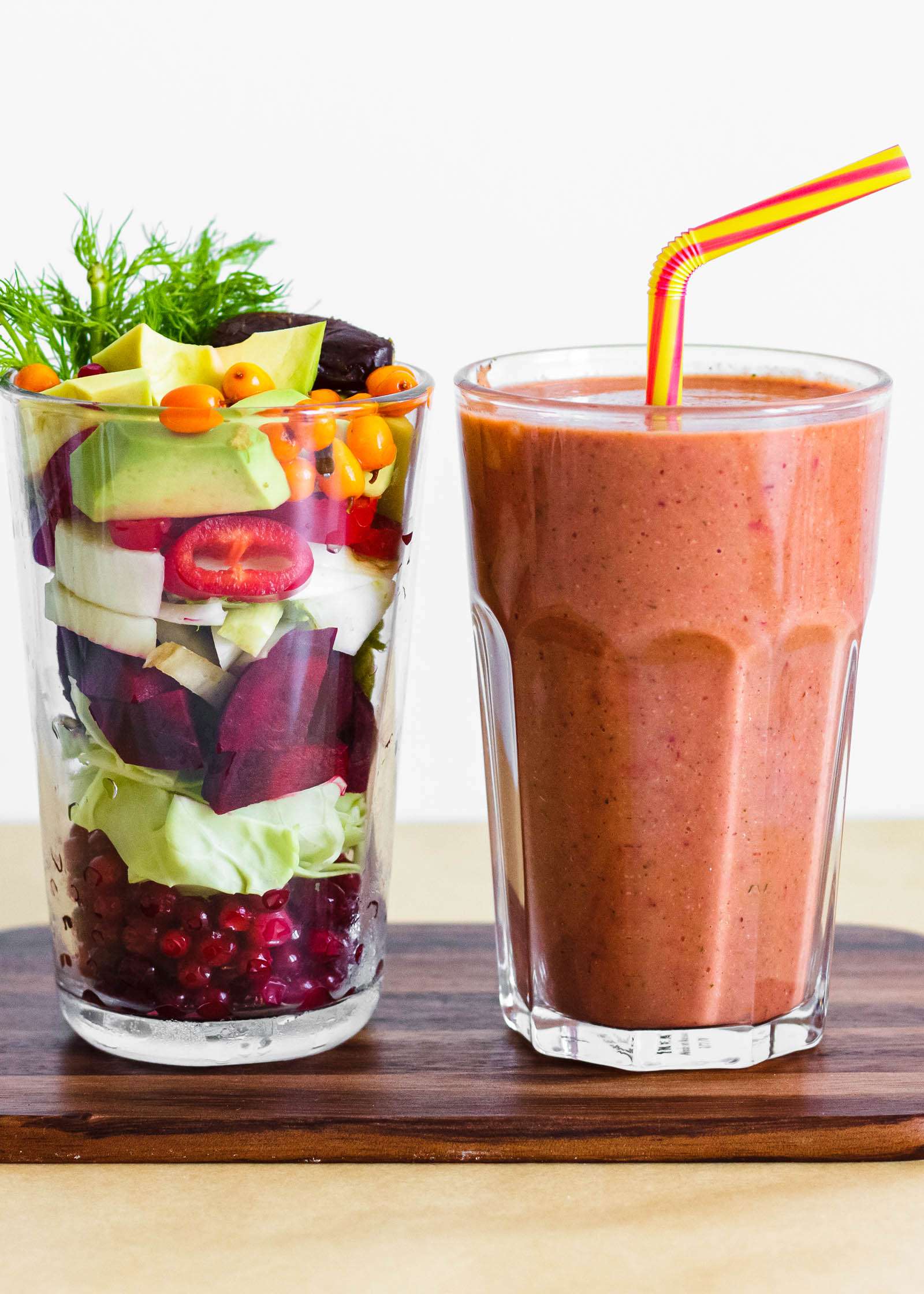 One glass with freshly made Berries, Veggies and Healthy Fats, Superfood Keto Smoothie, and another glass with fresh plants used for this smoothie
