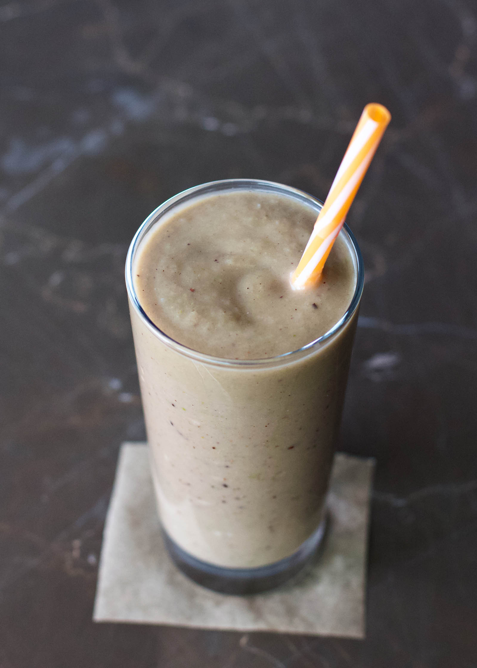 Glass of Simple Kiwi Apple Smoothie with drinking straw inside