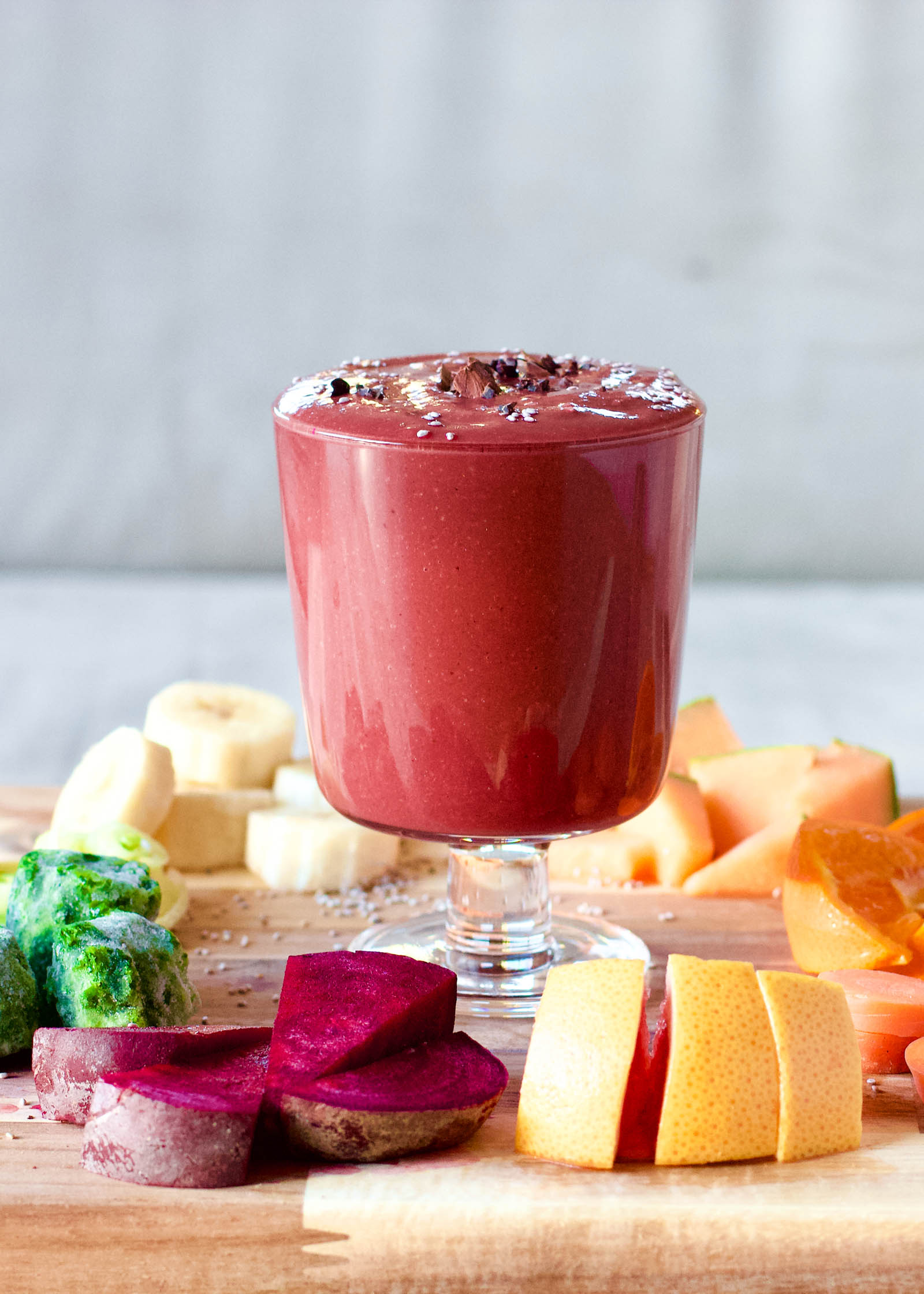 Glass of freshly made Sweet, Bitter and Spicy, Red Smoothie Rocket, surrounded by fresh plants