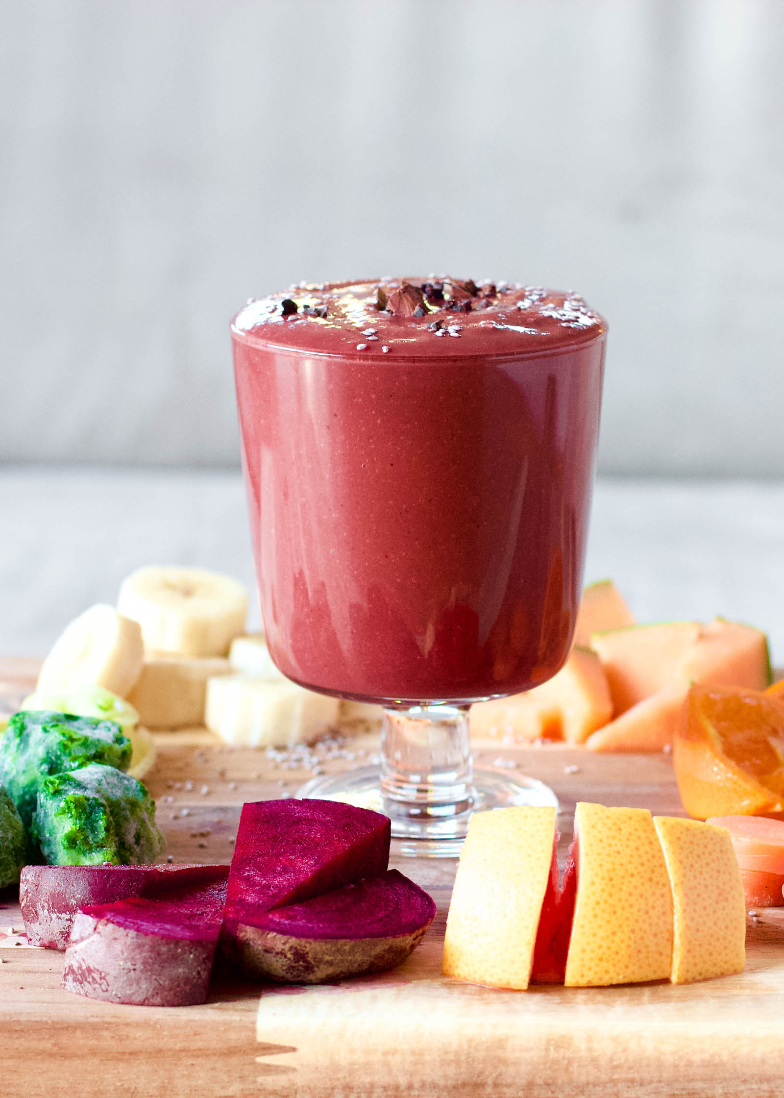 Glass of freshly made Sweet, Bitter and Spicy, Red Smoothie Rocket, surrounded by fresh plants